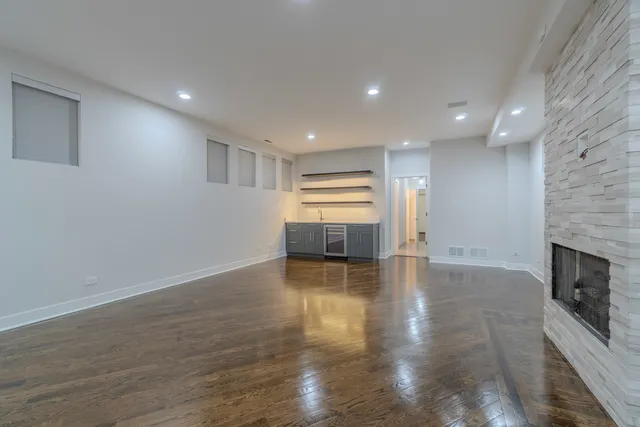 a view of empty room with wooden floor and fireplace