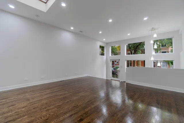 a view of an empty room with bookshelf and a wooden floor