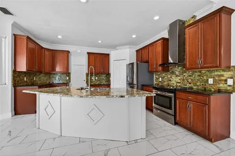 a kitchen with stainless steel appliances granite countertop wooden cabinets a stove top oven a sink and dishwasher