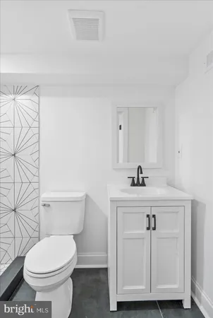 a bathroom with a sink a toilet and a mirror