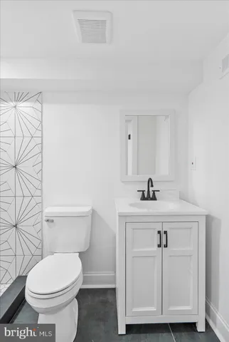 a bathroom with a sink a toilet and a mirror