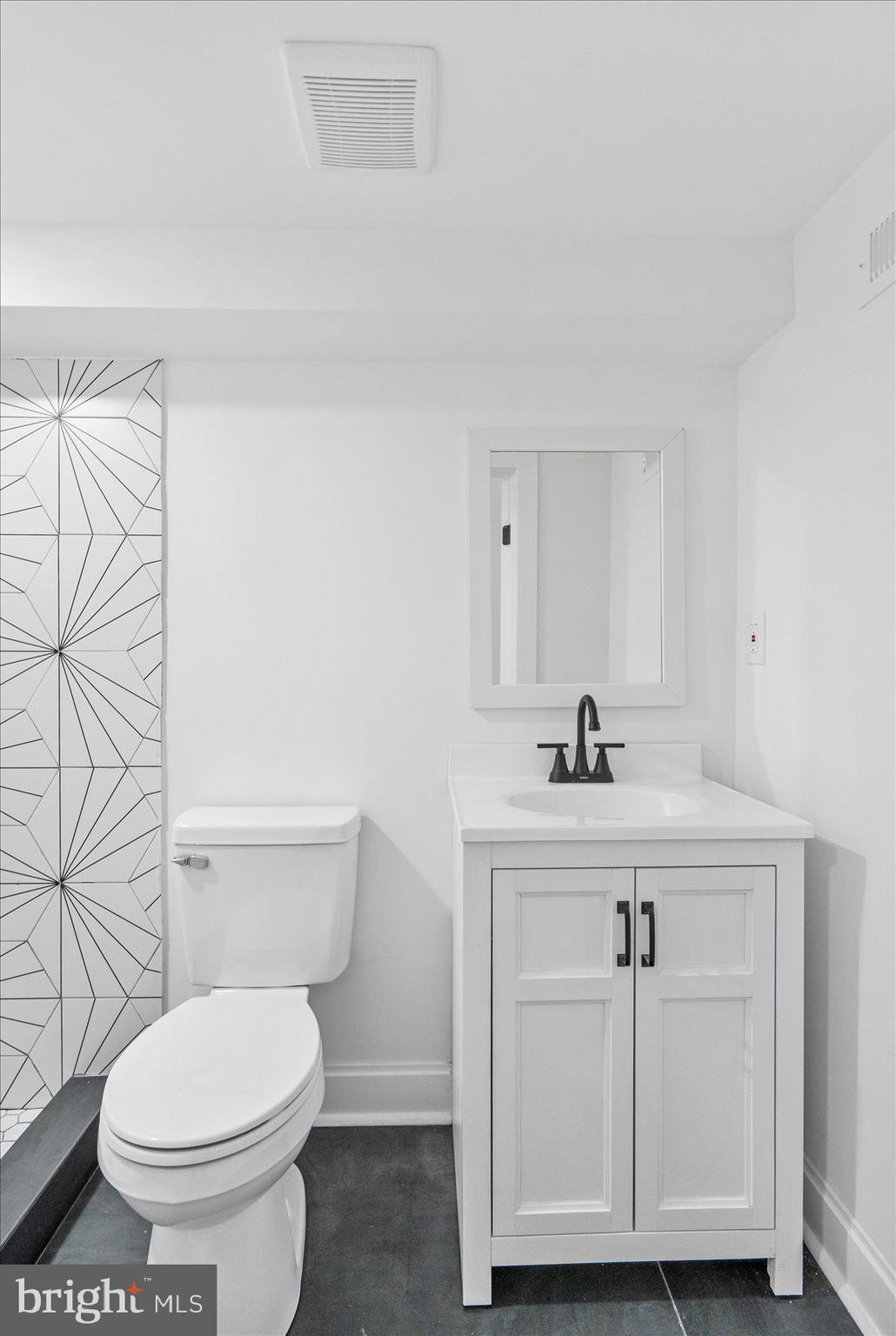 2436 East Biddle Street Baltimore, MD 21213 - Photo 15 of 33 a bathroom with a sink a toilet and a mirror