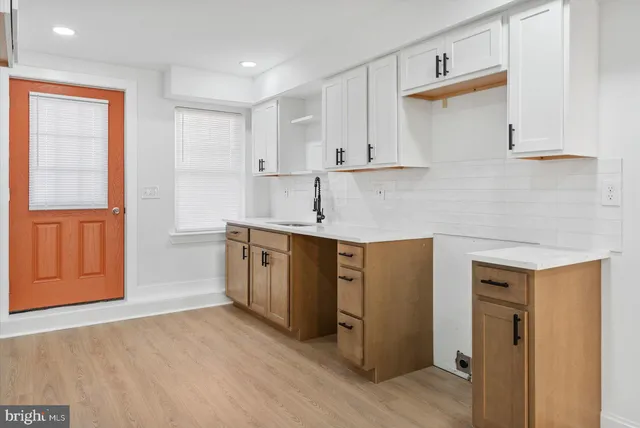 a kitchen with a sink cabinets and wooden floor