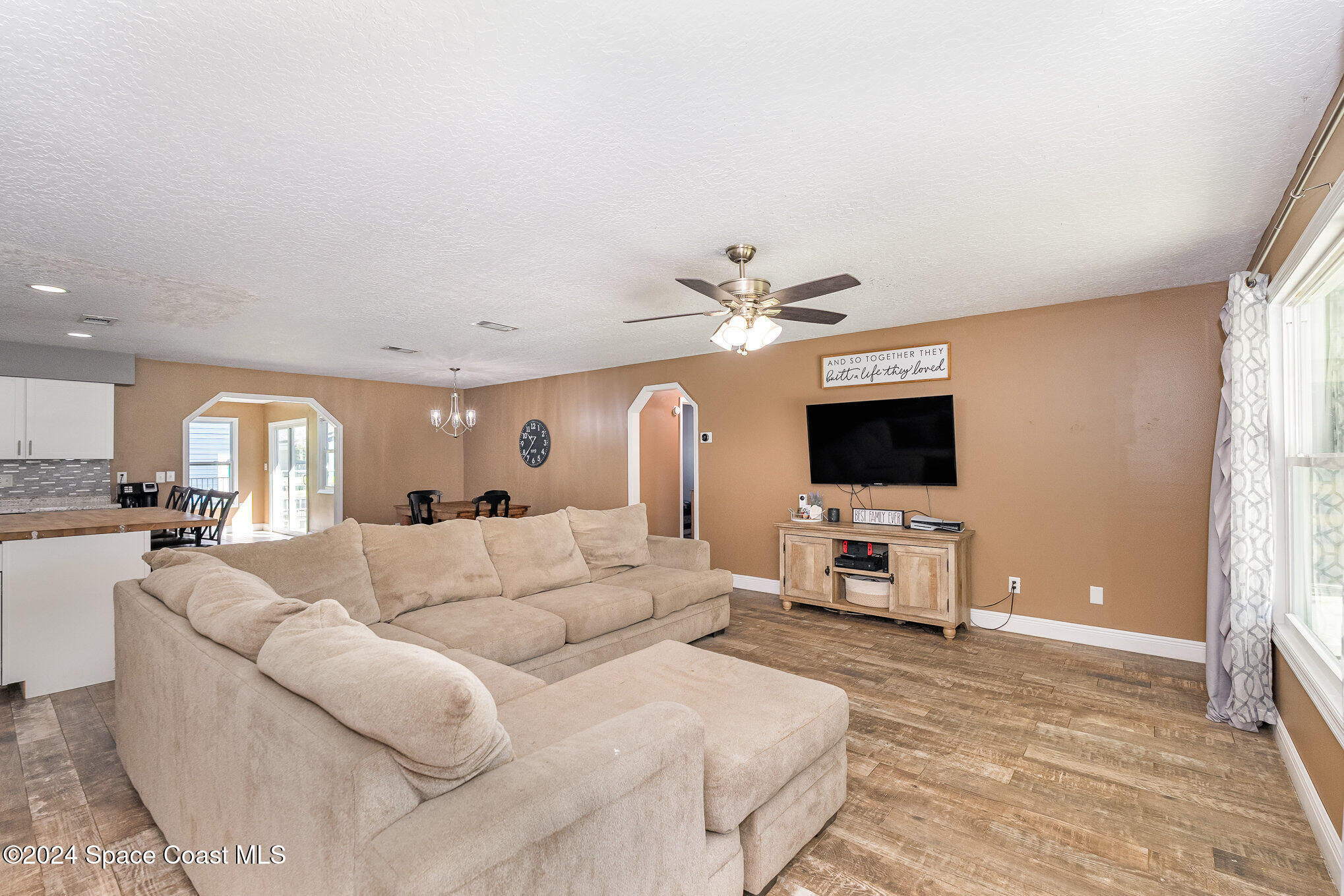 3330 Lionel Road Mims, FL 32754 - Photo 7 of 35 a living room with furniture a flat screen tv and a fireplace
