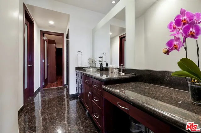 a bathroom with a granite countertop sink a mirror and vanity