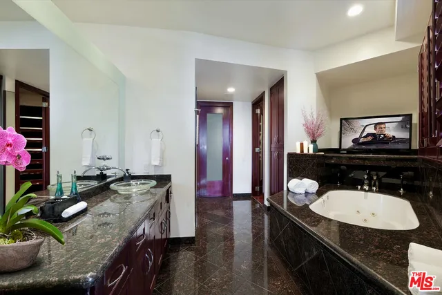 a bathroom with a granite countertop sink a mirror and vanity