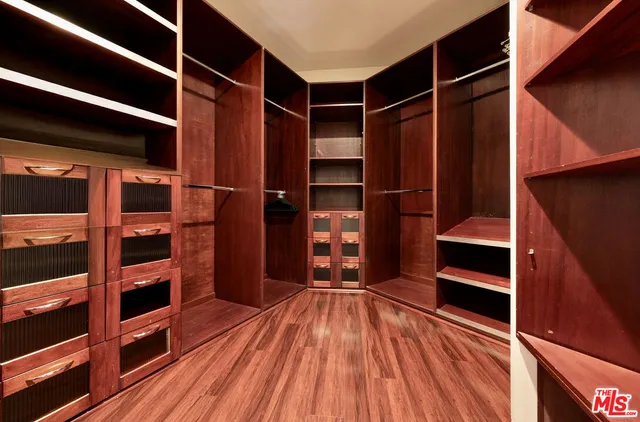 a view of walk in closet with empty racks