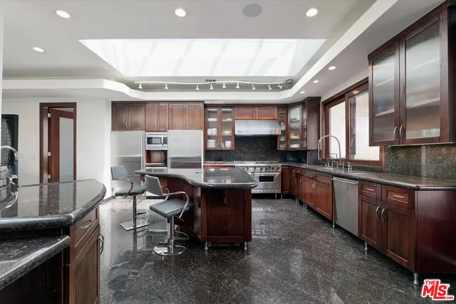 a large kitchen with a large counter top appliances and cabinets