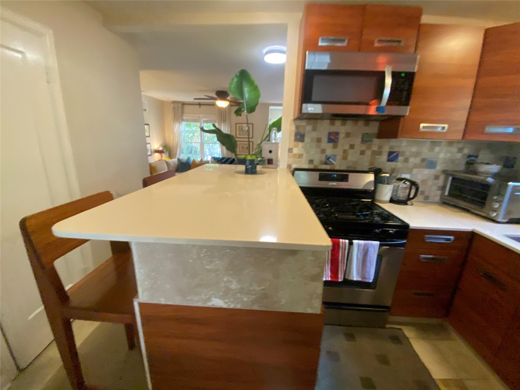 1404 West 12th Street, Unit C Austin, TX 78703 - Photo 11 of 34 a kitchen with stainless steel appliances granite countertop a sink a stove a microwave a refrigerator and cabinets