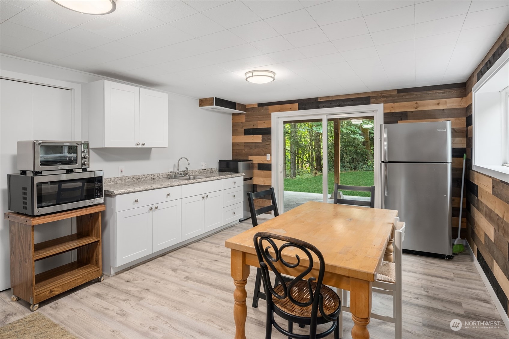 9523 Northeast 198th Street Bothell, WA 98011 - Photo 24 of 39 a kitchen with a refrigerator a stove a sink and a dining table with wooden floor