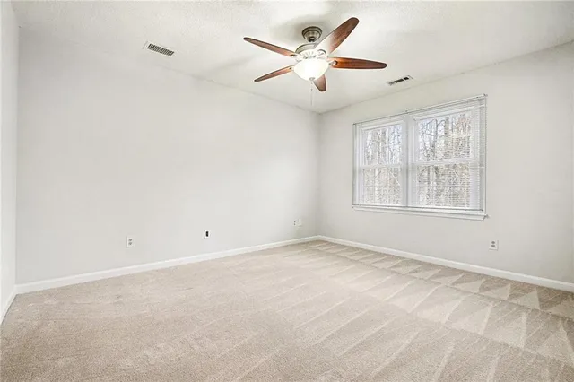 an empty room with chandelier fan
