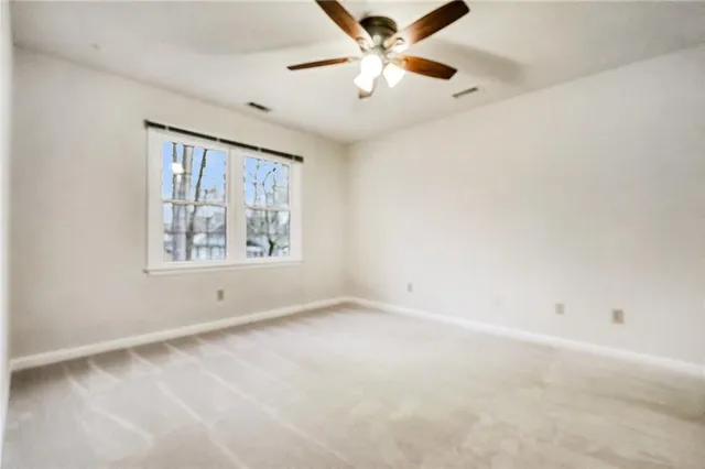 a view of empty room with cabinet and ceiling fan
