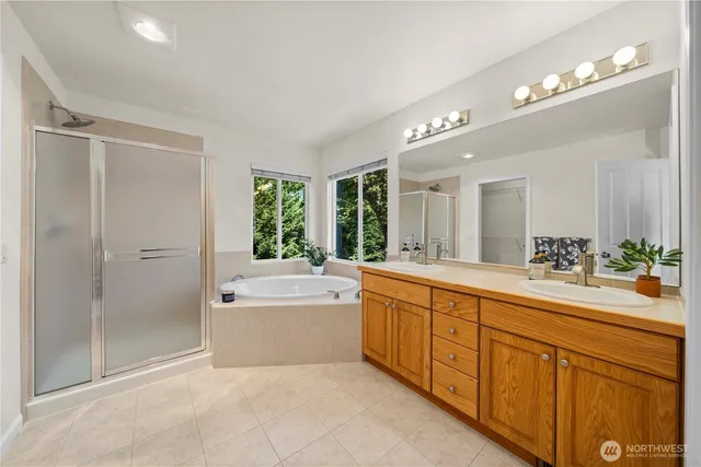 a bathroom with a tub a sink and a window