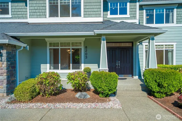 front view of a brick house with potted plants