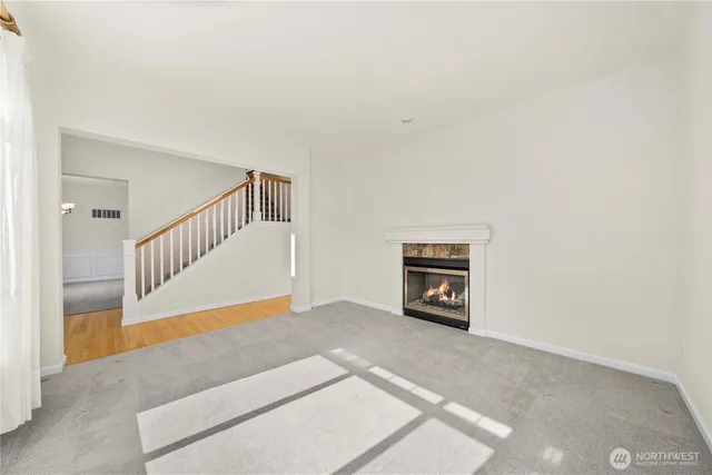 a view of an empty room with stairs and a couch