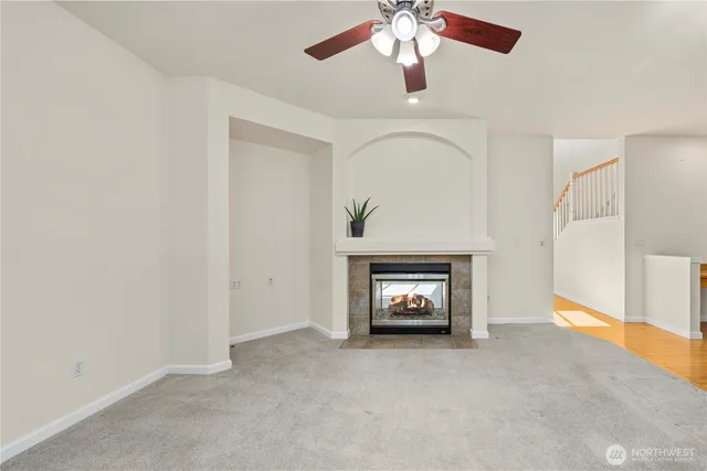 an empty room with windows and fireplace