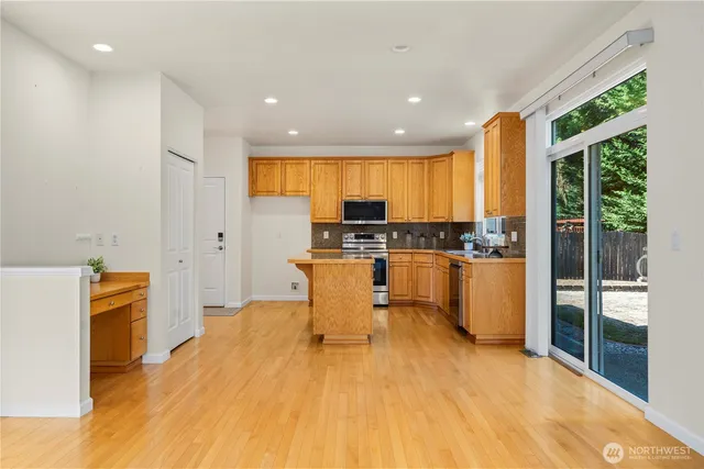 a kitchen with stainless steel appliances a stove a sink a refrigerator and cabinets