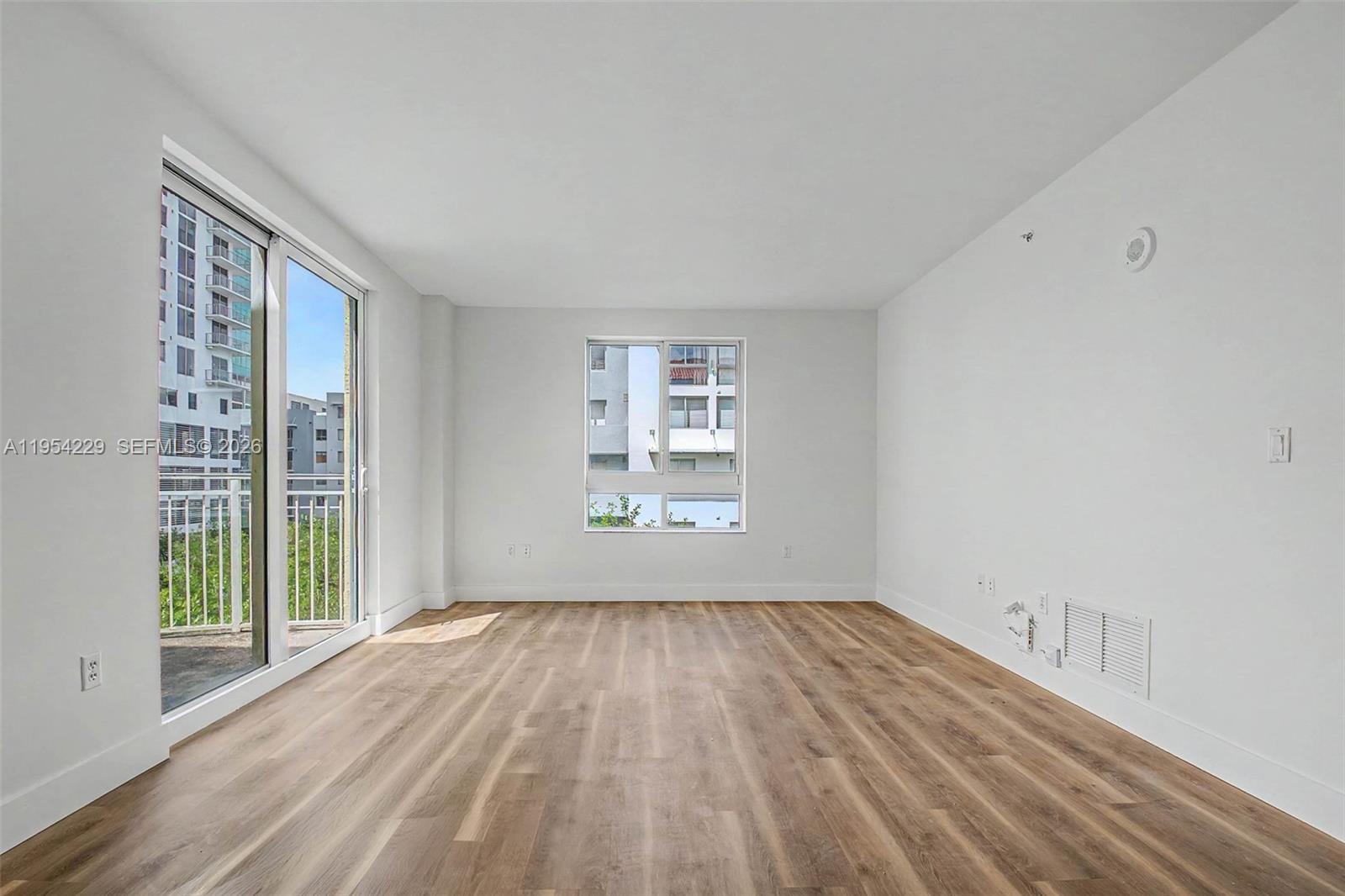 7355 Southwest 89th Street, Unit 502N Miami, FL 33156 - Photo 4 of 15 a view of an empty room with wooden floor and a window
