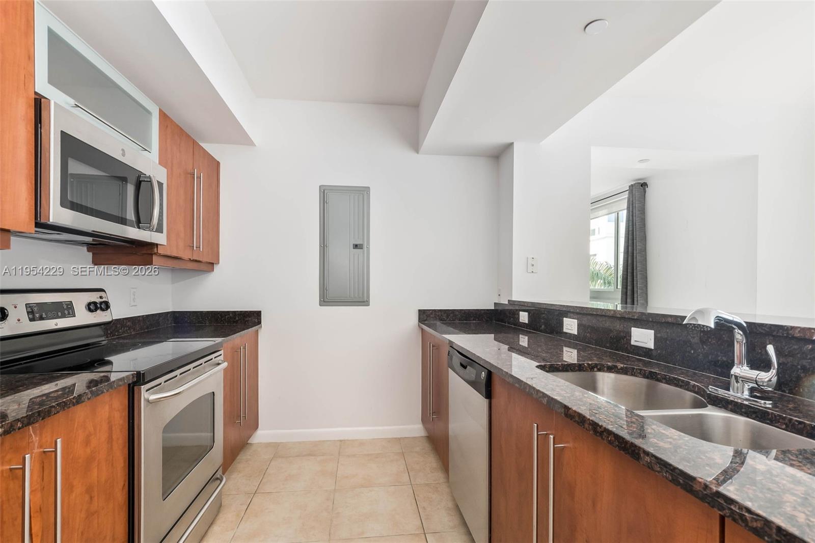 7355 Southwest 89th Street, Unit 502N Miami, FL 33156 - Photo 5 of 15 a kitchen with granite countertop stainless steel appliances a sink stove and microwave