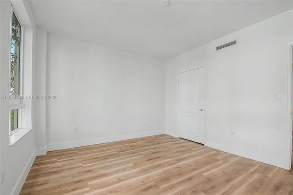 a view of empty room with wooden floor