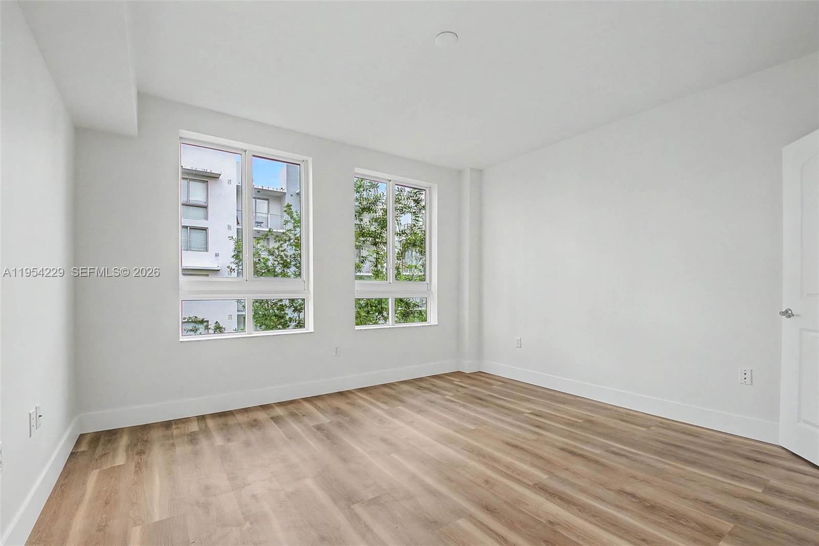 7355 Southwest 89th Street, Unit 502N Miami, FL 33156 - Photo 8 of 15 a view of an empty room with wooden floor and a window