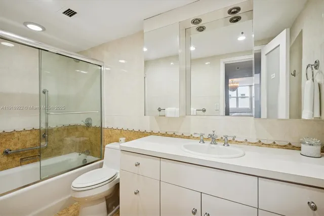 a bathroom with a granite countertop sink a toilet a mirror and shower