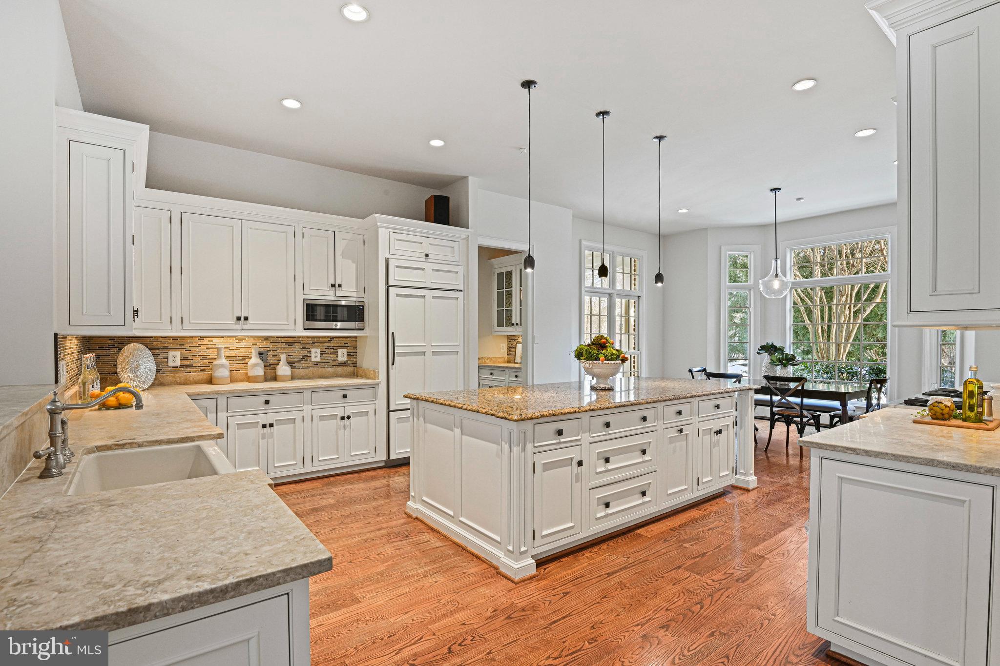 1064 Silent Ridge Court McLean, VA 22102 - Photo 17 of 70 a kitchen with granite countertop a white stove top oven and white cabinets