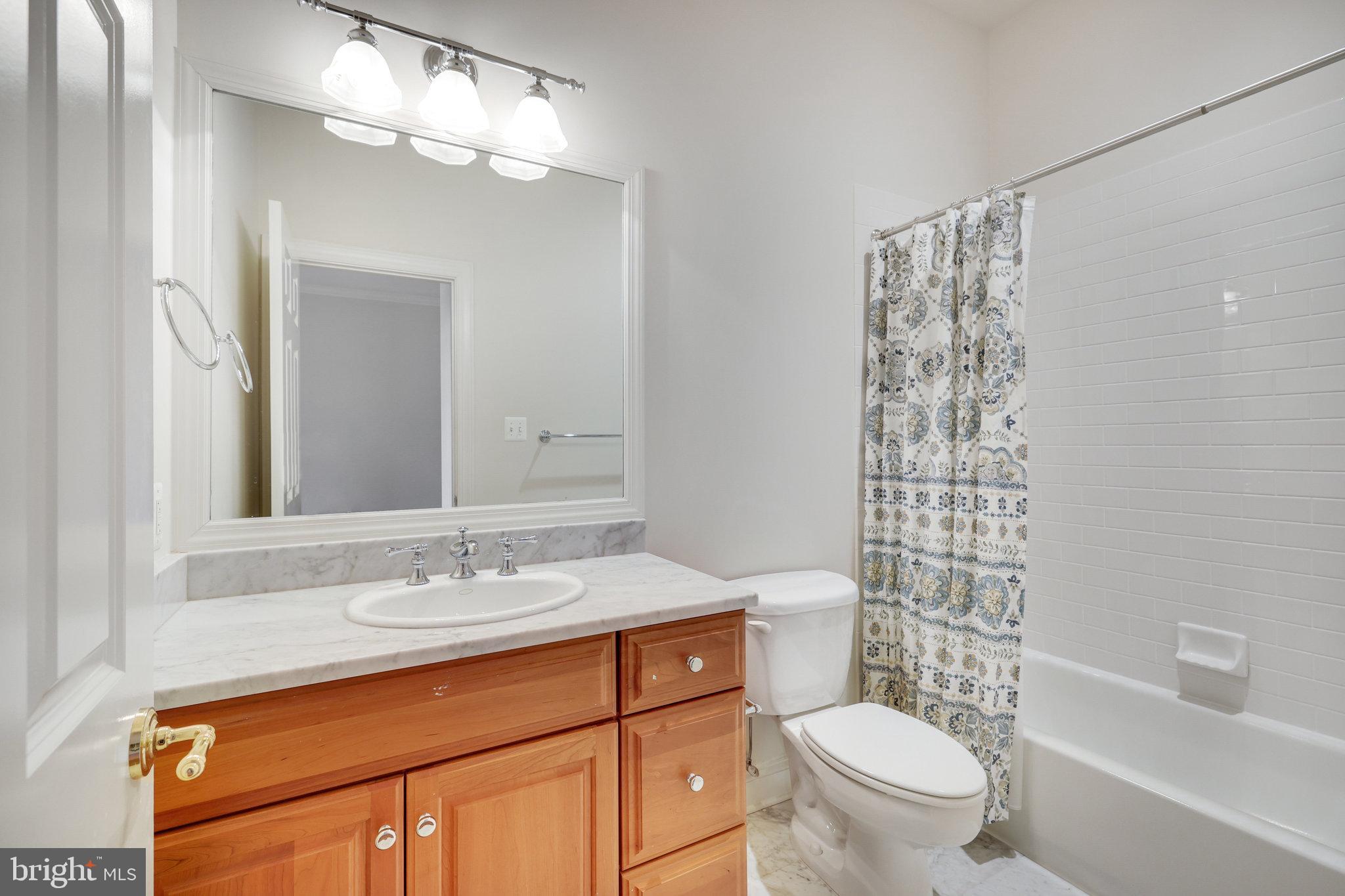 1064 Silent Ridge Court McLean, VA 22102 - Photo 35 of 70 a bathroom with a sink a toilet a mirror a vanity and shower