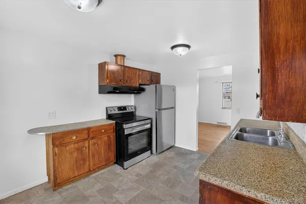 a kitchen with granite countertop a sink and a stove top oven