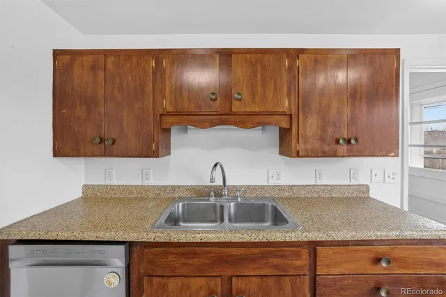 a kitchen with granite countertop stainless steel appliances wooden cabinets and a sink