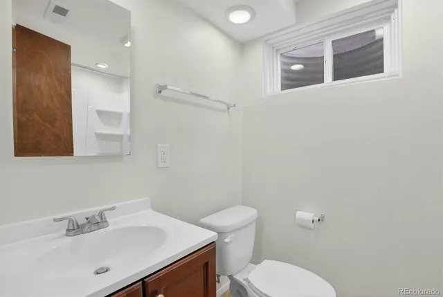 a bathroom with a sink mirror and toilet