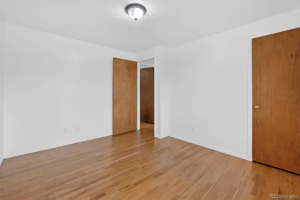a view of an empty room with wooden floor