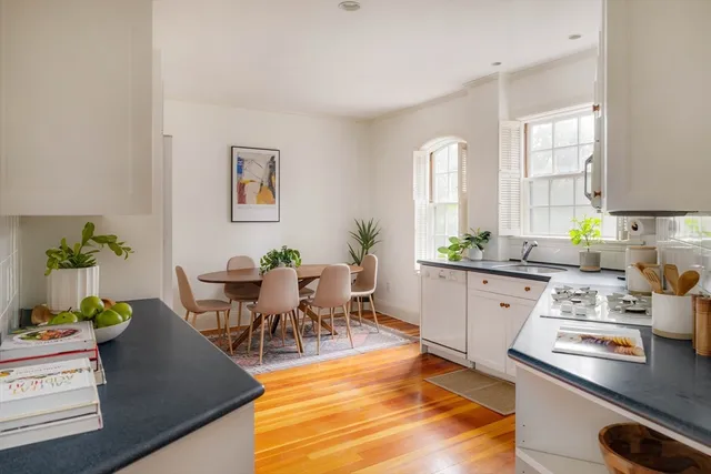 a kitchen with granite countertop white cabinets and a window