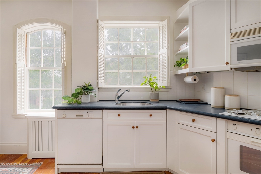 984 Memorial Drive, Unit 984503 Cambridge, MA 02138 - Photo 15 of 30 a kitchen with granite countertop white cabinets and a window