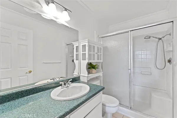a bathroom with a granite countertop shower sink mirror and toilet