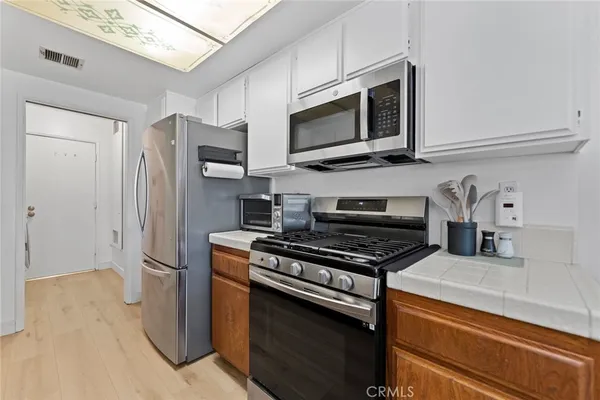 a kitchen with stainless steel appliances granite countertop a refrigerator stove and microwave