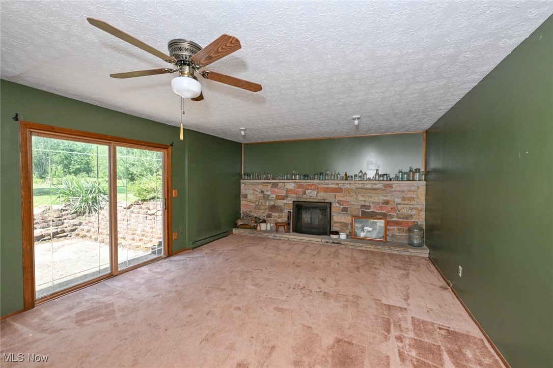 3079 Stroup Road Atwater, OH 44201 - Photo 33 of 40 Welcome to 3079 Stroup Rd, Atwater, OH 44201-9105 - The lower-level family room with a sliding door leading to the backyard patio, and a beautiful stone fireplace.
