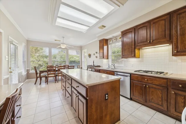 a kitchen with a stove a sink a dining table and chairs