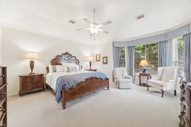 a spacious bedroom with a bed and a chandelier