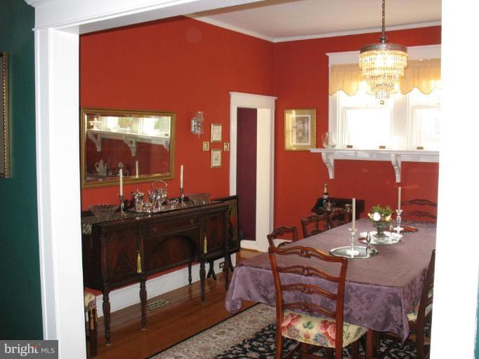 5103 Woodside Road Baltimore, MD 21229 - Photo 4 of 30 a view of a dining room with furniture a chandelier and wooden floor