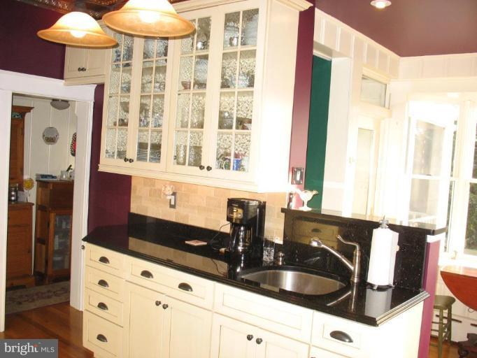 5103 Woodside Road Baltimore, MD 21229 - Photo 9 of 30 a kitchen with granite countertop a sink and a white cabinets