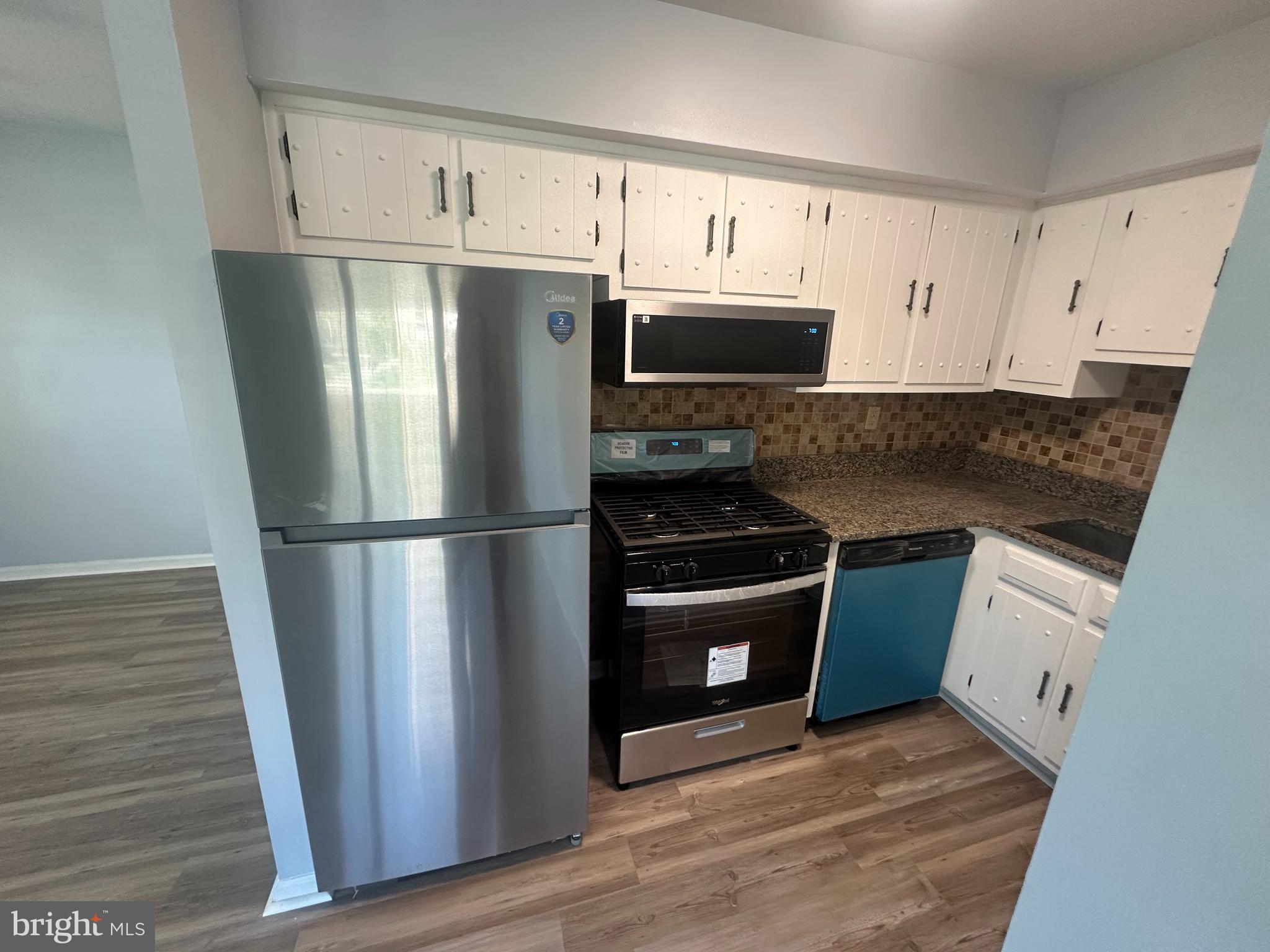5-7 Thomas Road, Unit 5 Aston, PA 19014 - Photo 6 of 13 a kitchen with stainless steel appliances granite countertop a refrigerator a stove a sink and white cabinets