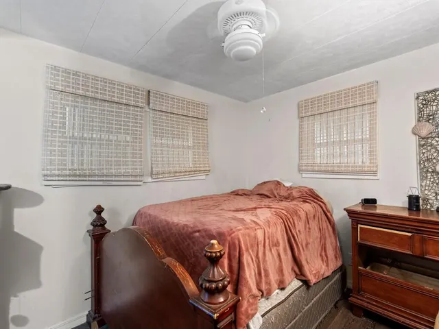 a bedroom with a bed and windows