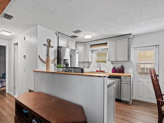 a kitchen with a sink cabinets and wooden floor