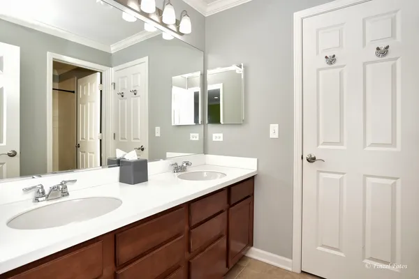 a bathroom with double vanity sinks and a mirror