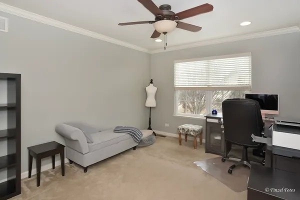 a view of a workspace with furniture and a window