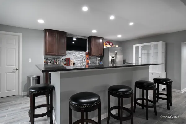 a kitchen with kitchen island granite countertop a table and chairs in it