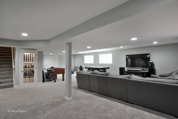 a kitchen with stainless steel appliances kitchen island granite countertop a refrigerator a stove a sink a dining table and chairs with wooden floor