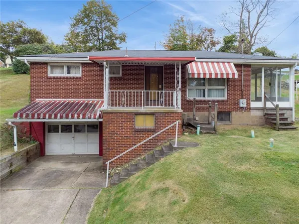 a view of a house with a yard and sitting area