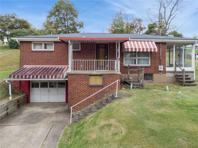 a view of a house with a yard and sitting area